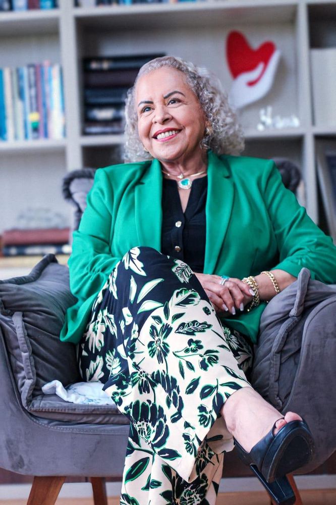 Pastora Tânia Tereza rindo em uma biblioteca